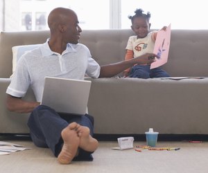 Daughter (2-4) showing father picture indoors