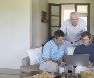 Father with his two sons looking at a laptop