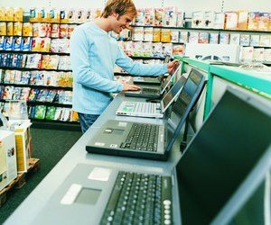 Young Man Looking at a Laptop in a Computer Shop
