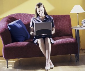 Young woman sitting on a couch using a laptop