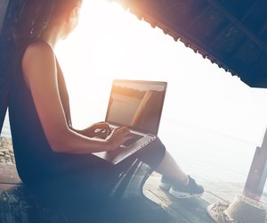 Woman working with laptop on the beach