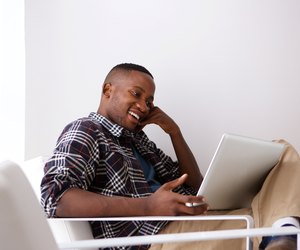 Happy young man using laptop at home