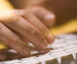Close-up of person typing on a computer keyboard