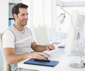 Smiling casual young man using computer