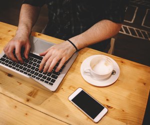 Young man sitting in a coffee shop using laptop