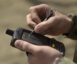 U.S. Marine using GPS capabilities on a handheld device to check his location.