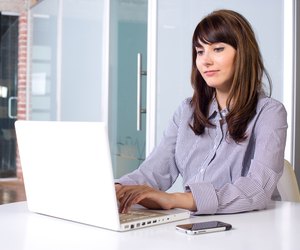 Business Woman on laptop in a modern loft office