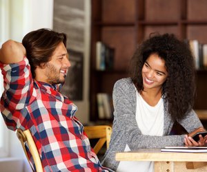Man and woman sitting at table with laptop and phone