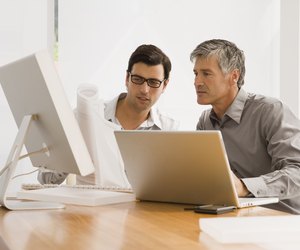 Two businessmen discussing a blueprint in an office
