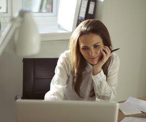 Beautiful young woman working from home using laptop