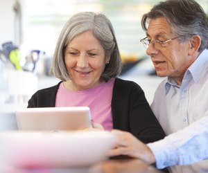 Senior couple using digital tablet at home