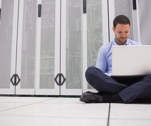 Technician sitting on floor working on laptop