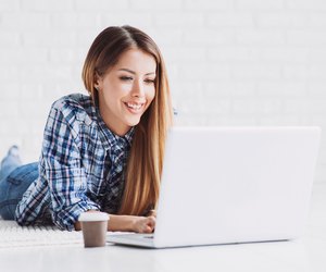 Happy student girl using laptop at home