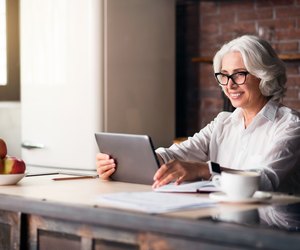 Elegant elderly woman using laptop