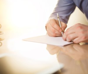 The male hands with a pen and the cup