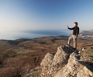 Man with mobile phone on the top of world