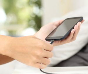 Woman hands plugging a charger in a smart phone