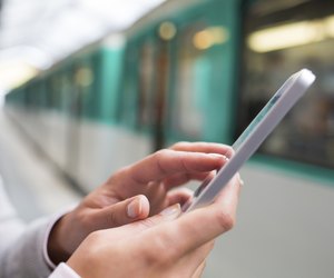 Woman using her cell phone on subway platform