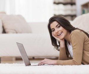 Smiling woman relaxing at home with laptop