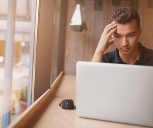 handsome hipster modern man working inside cafe at window