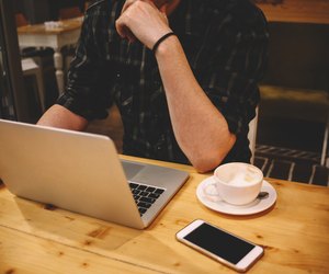 Young man sitting in a coffee shop using laptop