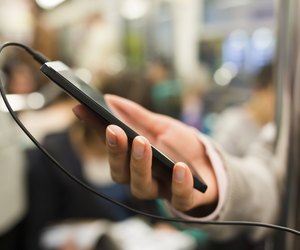 Woman listens to music with her cell phone in subway
