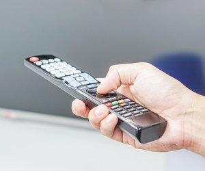 Turn on TV with remote control in hand