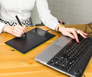 Close-up of designer using graphics tablet while working with