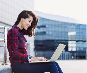 Student girl using laptop outdoors