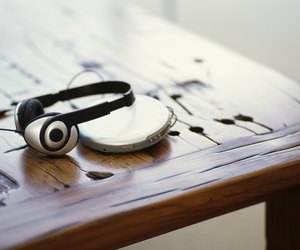 headphones and a personal stereo on a wooden table