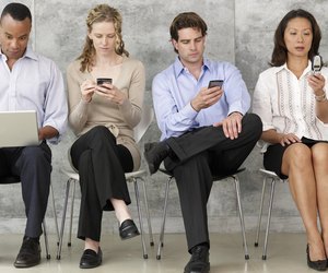 Four People Using Communication Equipment