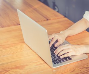 Hand woman typing key pad of laptop.