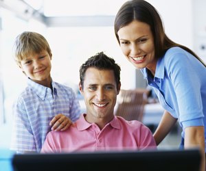 parents with their son looking at a computer