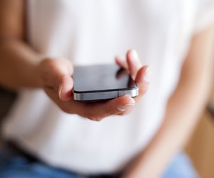 Young woman handing smartphone