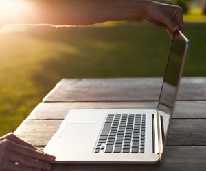 Man uses a laptop in the park
