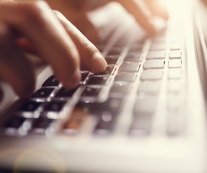 Hands typing on laptop computer