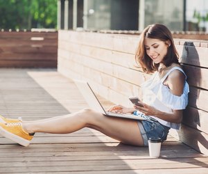 Young trendy girl using a laptop outdoors