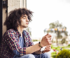 Young man listening music with digital tablet