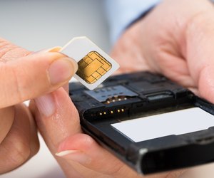 Person Hand With Sim Card And Mobile Phone