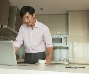 Businessman in front of his computer drinking coffee at home
