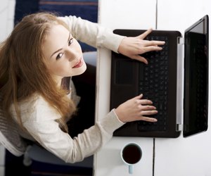 Beautiful caucasian woman sitting with hot drink and working on