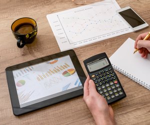 business concept - graph, calculator, tablet and pen on desk