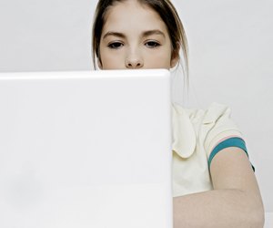 View of a teenage girl working with a laptop.