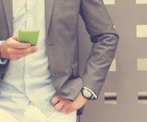 Elegant man using cellphone outdoors.