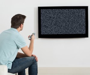 Man Sitting On Sofa In Front Of Television