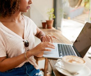 Young woman working on laptop in cafe