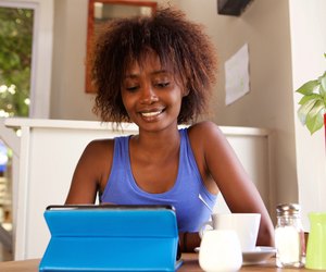 Smiling young woman using digital tablet at cafe