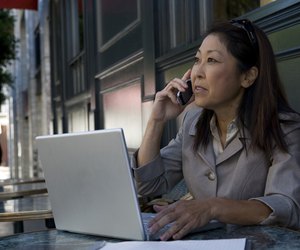 Businesswoman using laptop and mobile phone
