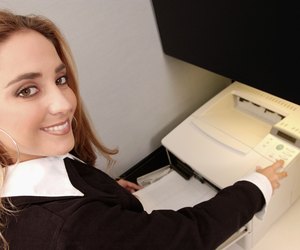 Young blonde female is office worker at fax machine