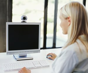 rear view of a mid adult woman using a computer